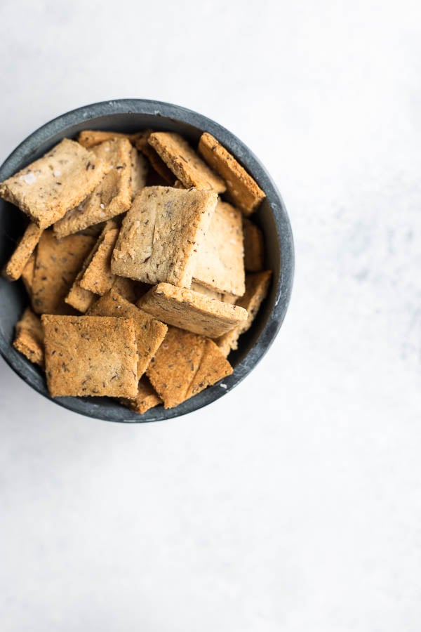 Vegan Garlic Herb Almond Flour Crackers: Make crunchy, delicious crackers at home in 30 minutes! Naturally gluten free and vegan, and super simple to make! || fooduzzi.com recipe