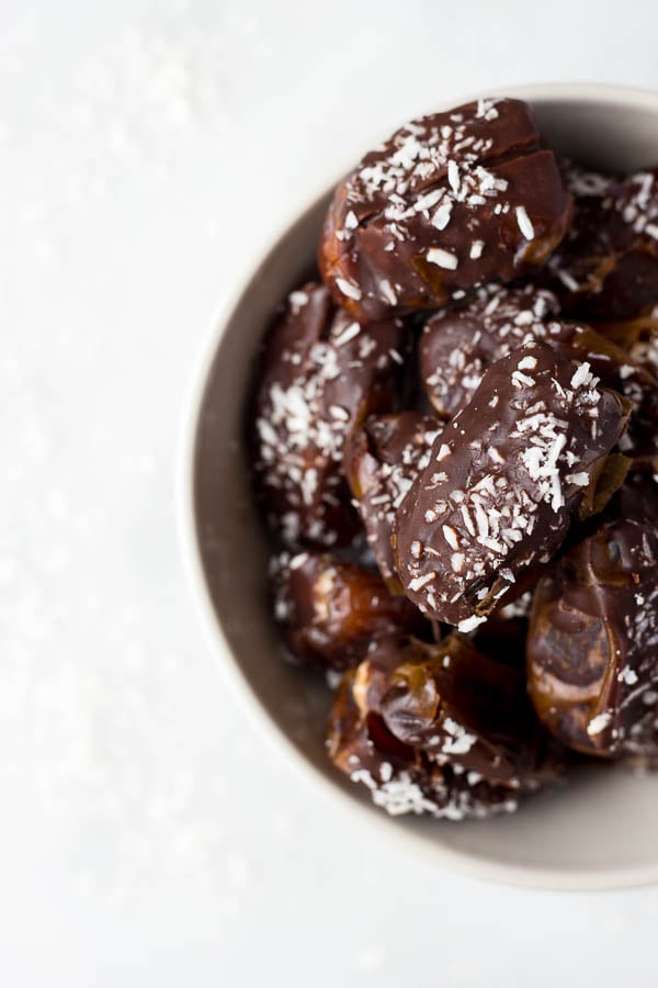 Almond Joy Dates: made with healthy ingredients like almond butter, unsweetened coconut, and a homemade chocolate sauce! These gluten free and vegan treats are the perfect summer snack or dessert, and they require only 6 ingredients! || fooduzzi.com recipe