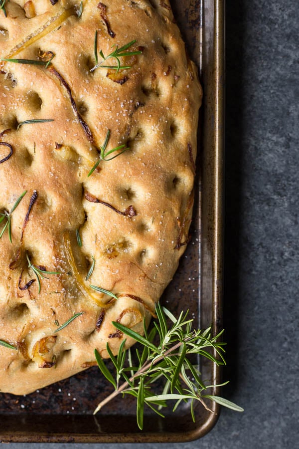 Caramelized Onion Rosemary Focaccia Bread: Tender, rich homemade bread made slightly sweet and herby. Naturally vegan, and the perfect accompaniment to an Italian feast! An easy yeast dough recipe! || fooduzzi.com recipes