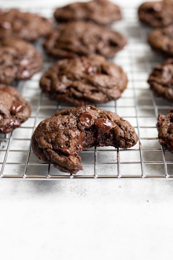 A cooling rack with Chocolate Beer cookies and a bite taken out of the front cookie