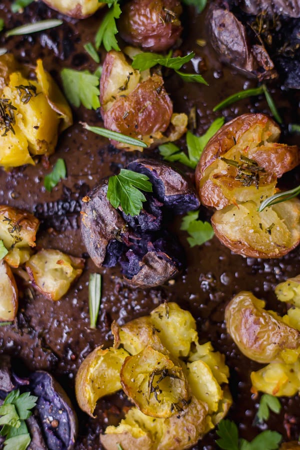 Crispy Vegan Smashed Potatoes: Tender, crispy, herby, and garlicky! These potatoes are absolutely heavenly as a Thanksgiving or holiday side! || fooduzzi.com recipe