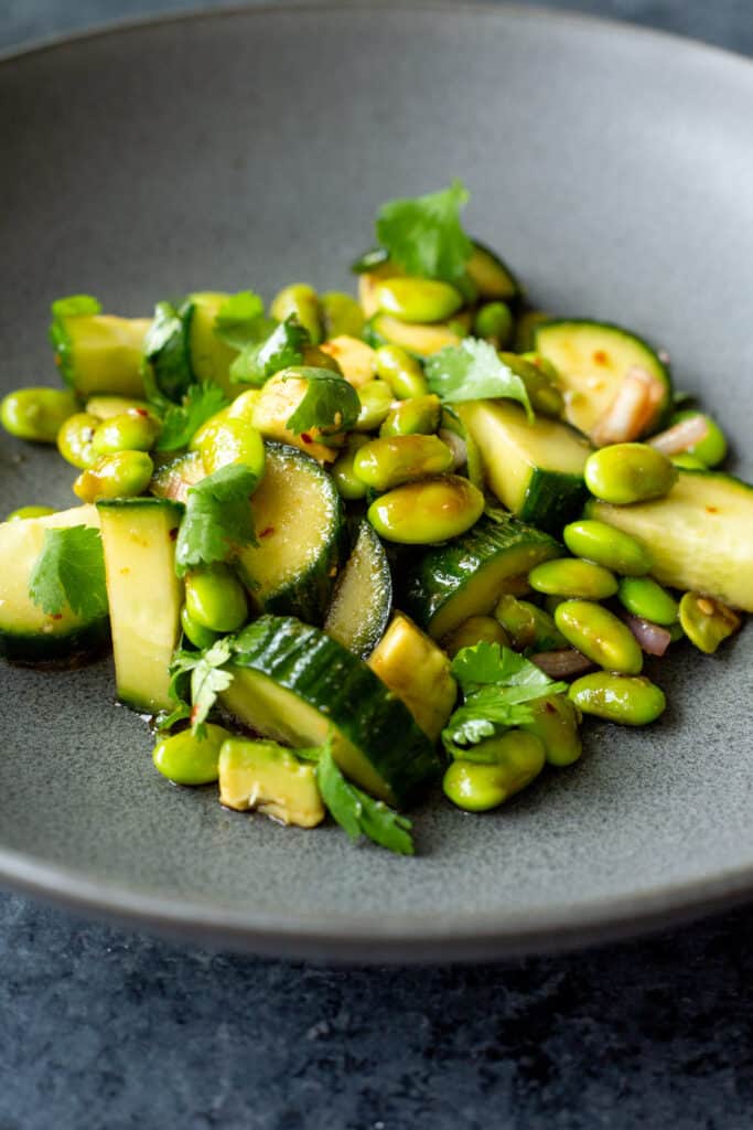 a close-up shot of the Cucumber, Edamame, Avocado Salad in a dark bowl