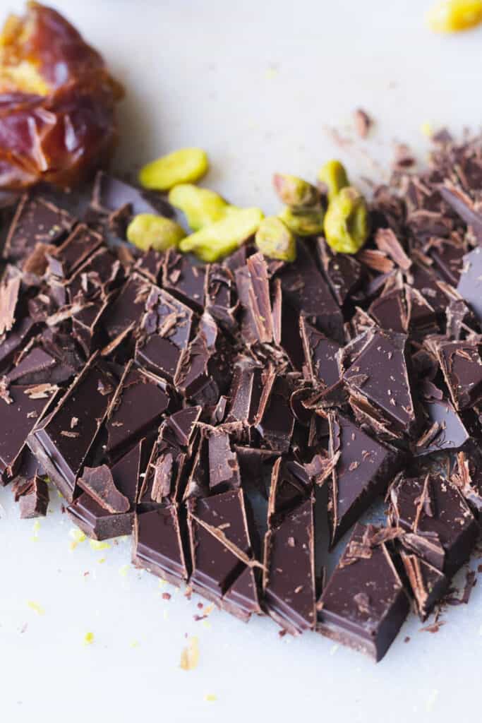 chopped chocolate and pistachios on a cutting board
