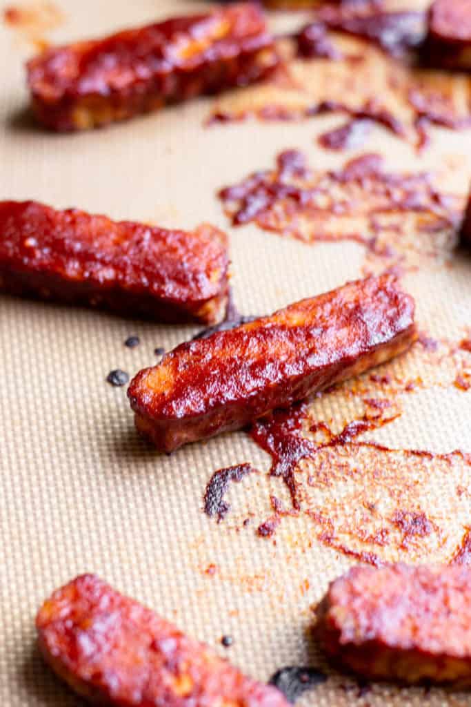 Sliced BBQ Tempeh on a silicone baking sheet