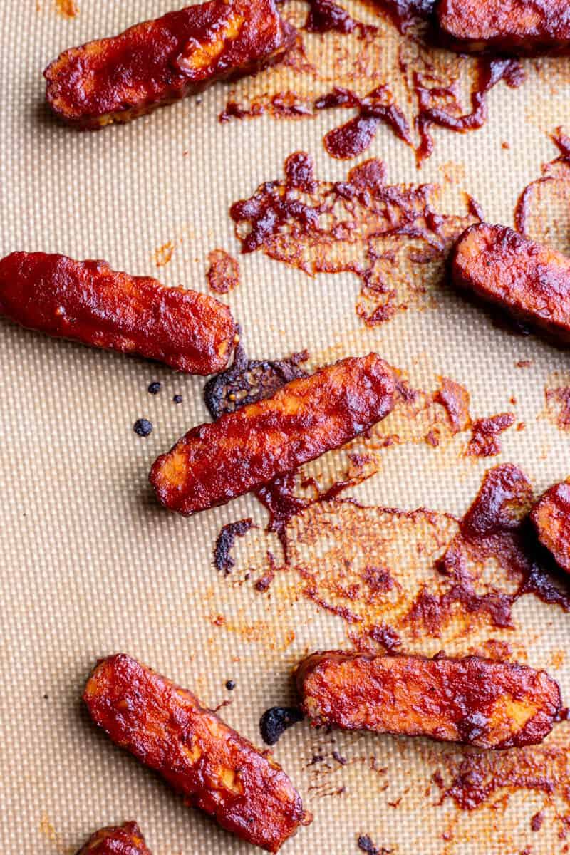 Sliced BBQ Tempeh on a silicone baking sheet after being baked
