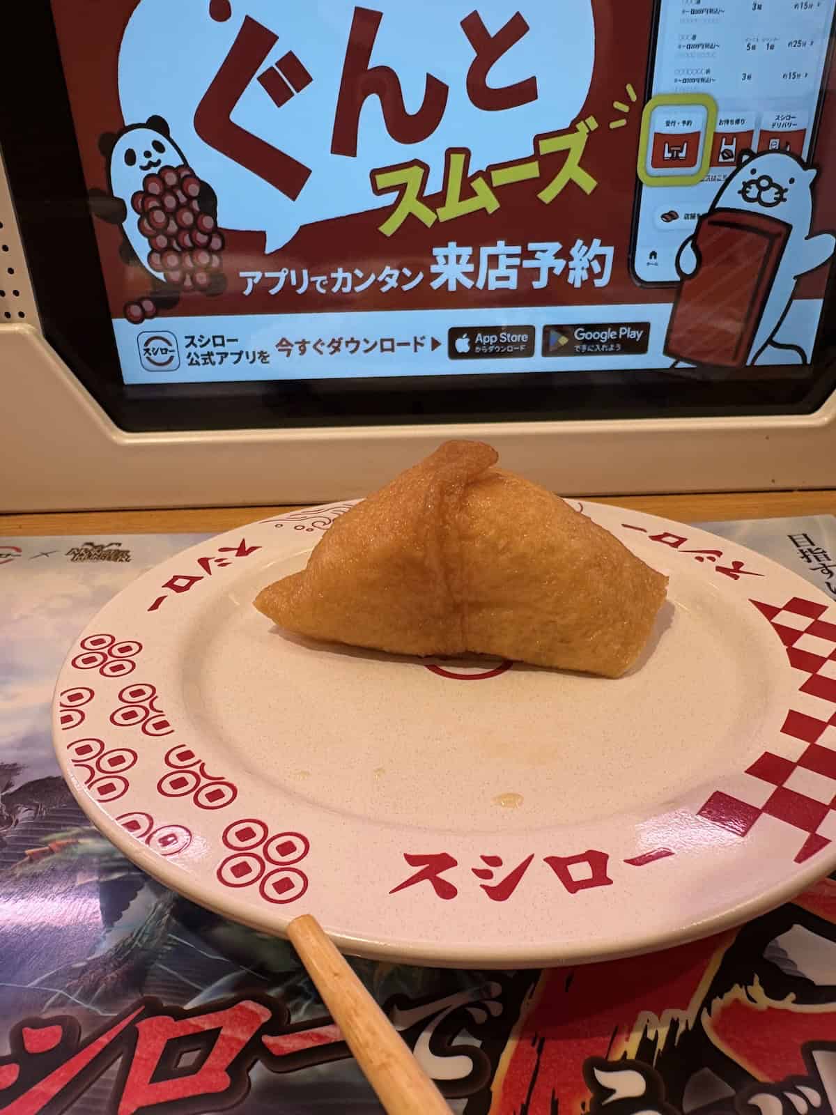 The fried bean curd at Sushiro in Kyoto on a white and red plate in front of a screen