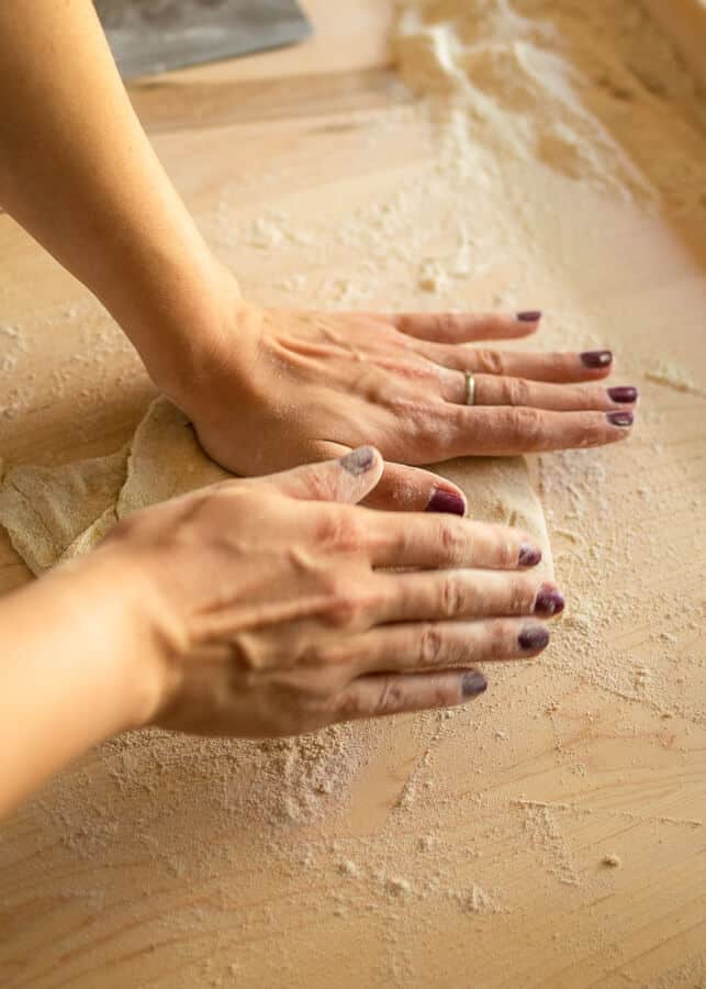 two hands folding pasta dough