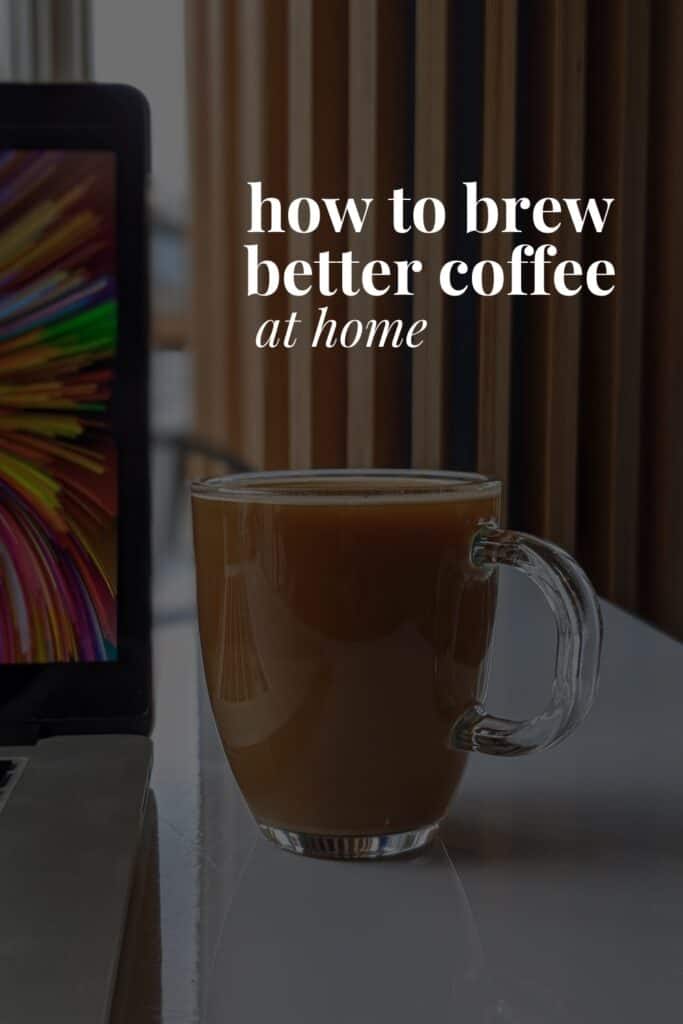 a mug of coffee next to a computer and the title of this article 'how to brew better coffee at home'
