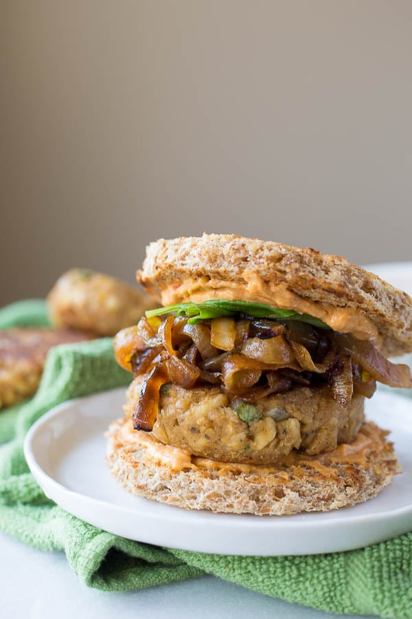 Italian-Style Chickpea Burgers: packed with healthy, vegan, and gluten free ingredients and topped with caramelized onion, hummus, and basil! Perfect for Father's Day and summer cookouts! || fooduzzi.com recipe