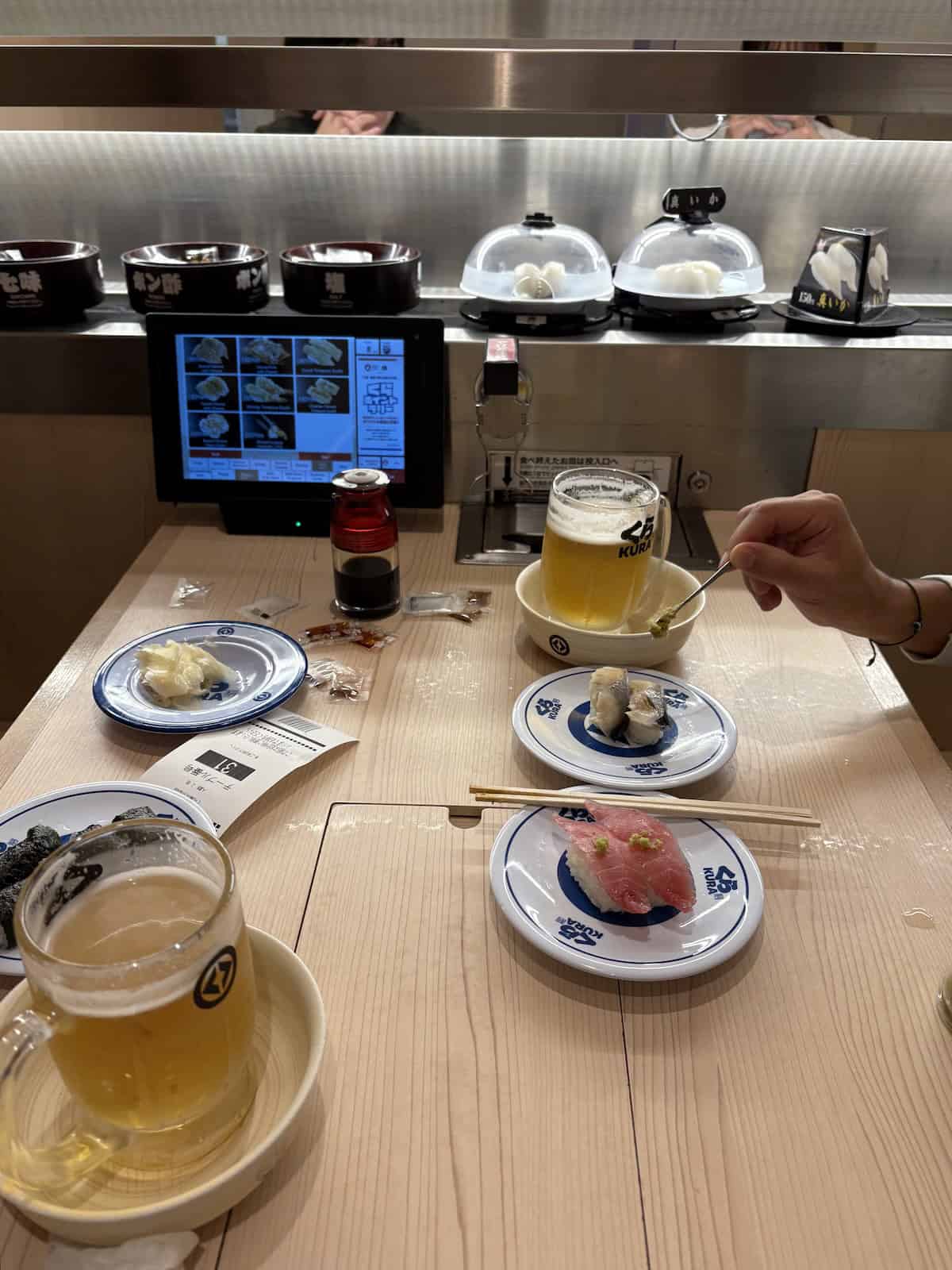 The table at Kura Sushi with a screen and sushi on the table