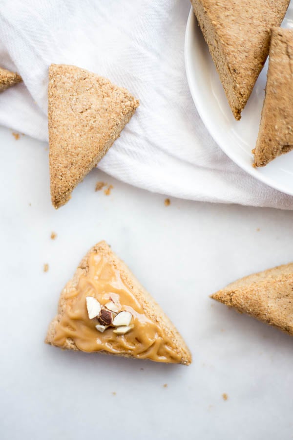 Mini Almond Butter Pumpkin Spice Scones: A three-bite vegan and gluten free scone that's spiked with fall flavors! Naturally sweetened and topped with a creamy maple almond butter icing, you can enjoy these scones for breakfast, a snack, or dessert! || fooduzzi.com recipe