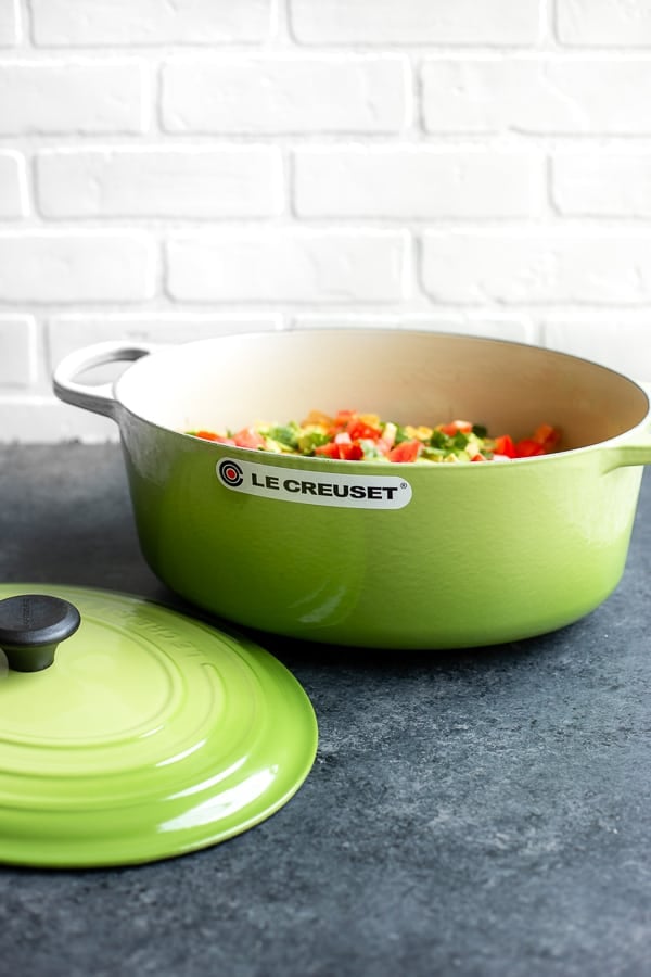 a Le Creuset oval dutch oven filled with a one-pot vegan enchilada cassrole