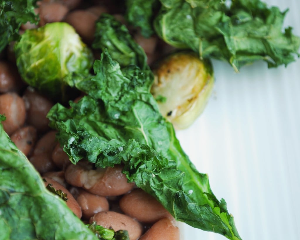 Kale & Pinto Beans: Crispy kale, creamy pinto beans, and sweet roasted brussels make up this play on a restaurant favorite! Filled with protein and vitamins, this healthy gluten free and vegan entrée is sure to satisfy! || fooduzzi.com