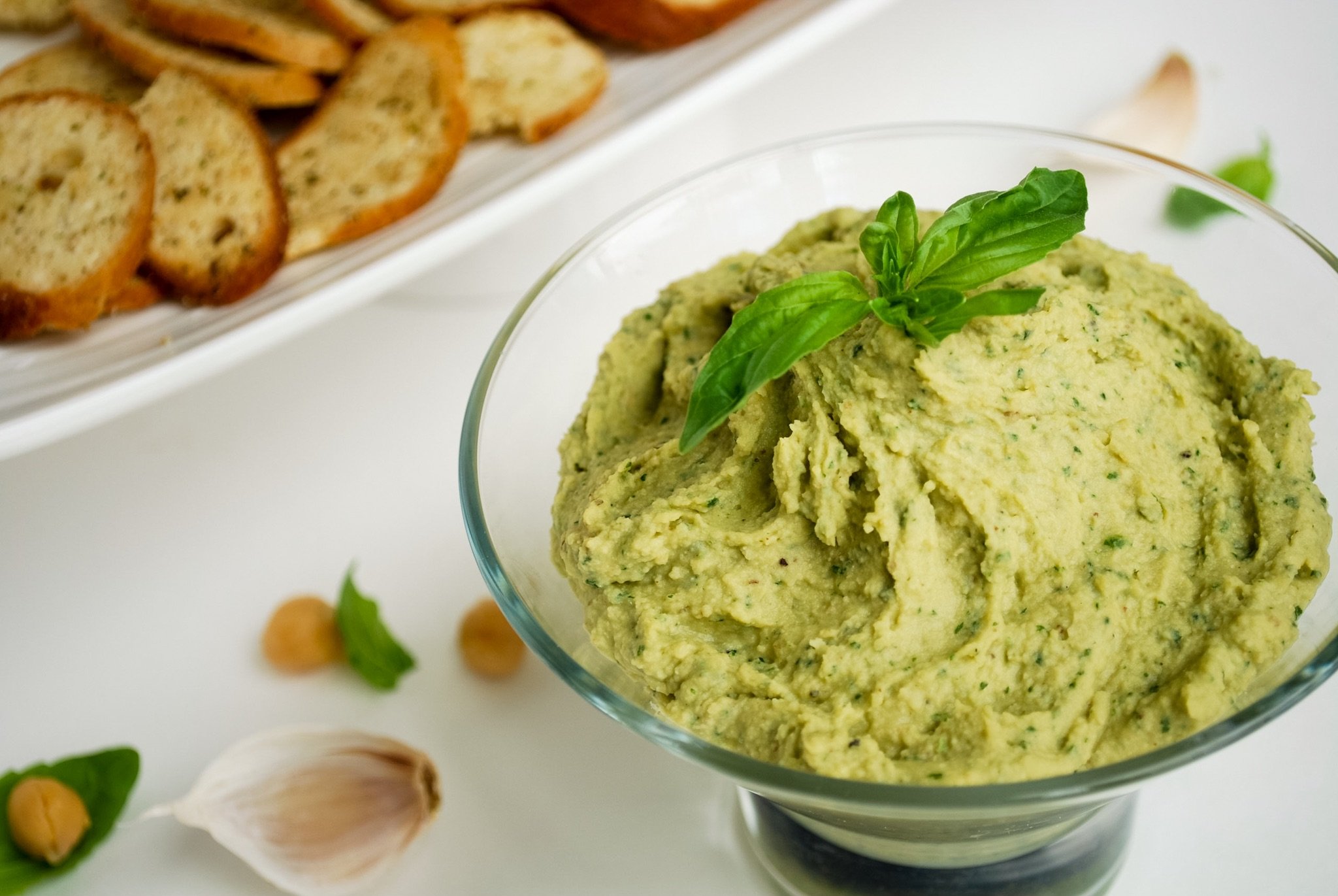 Pesto Hummus: Packed with flavor, this vegan and gluten free hummus is sure to impress! It's a healthier take on the classic Italian pesto! || fooduzzi.com