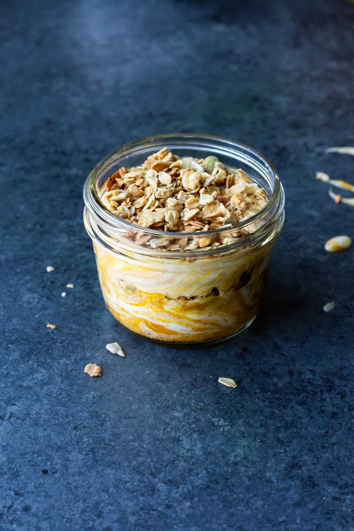 a jar of vegan pumpkin swirl granola parfait topped with granola