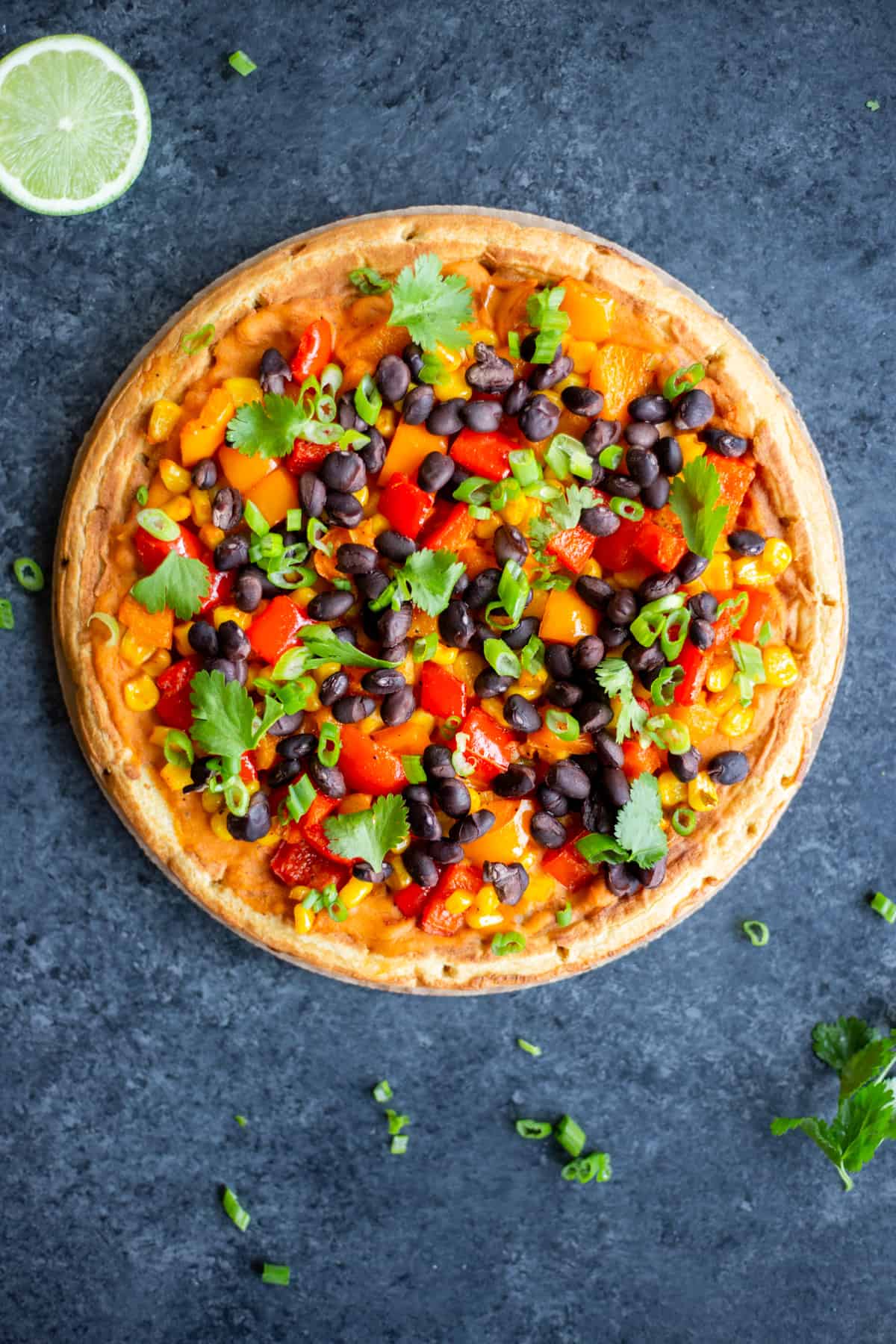 A Smoky Pepper, Corn, and Black Bean Flatbread on a dark background