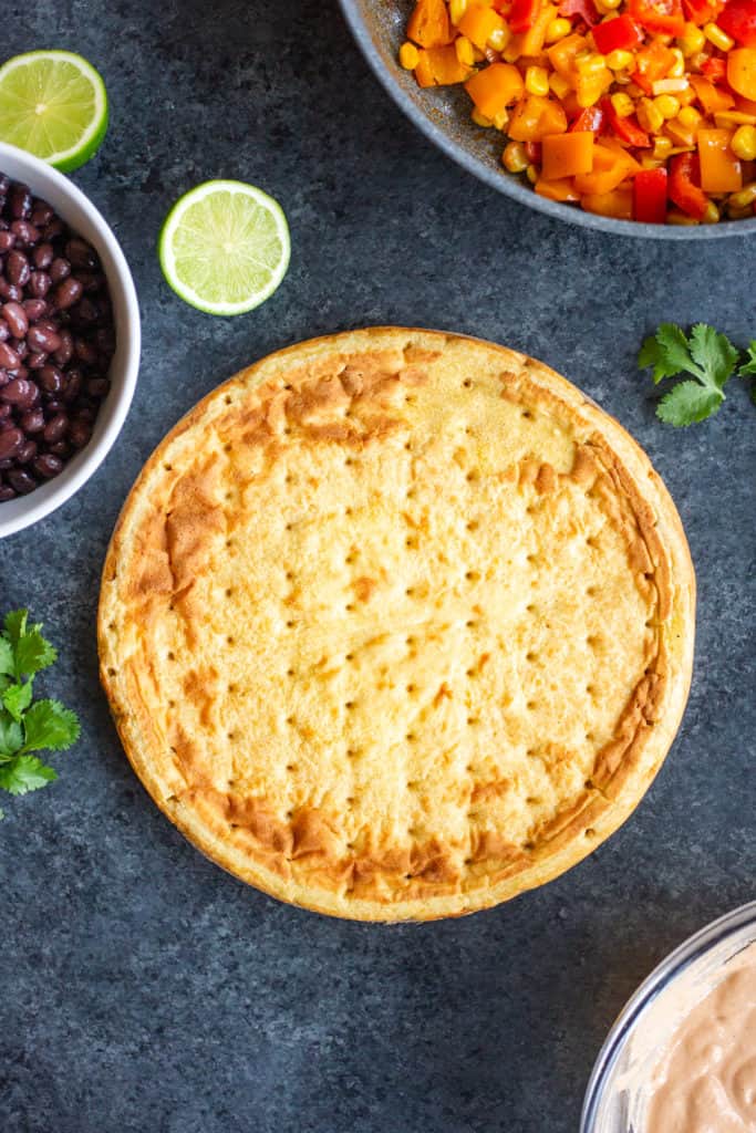 a flatbread crust with peppers, black beans, and sauce surrounding it