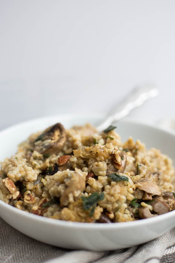 Steel Cut Oat Stuffing with Mushrooms & Fried Sage: A warm and comforting Thanksgiving staple! This gluten free & vegan stuffing is loaded with garlicky mushrooms, fried sage, and crispy pecans! || fooduzzi.com recipe