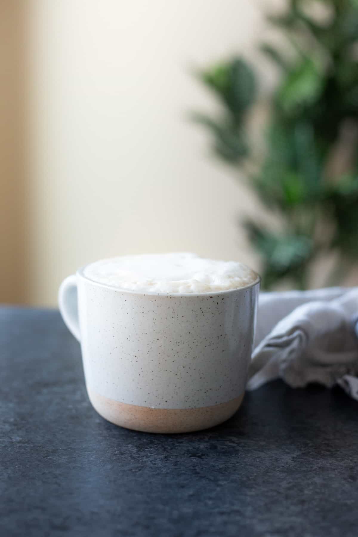 A ginger latte on a dark board with a tree in the background