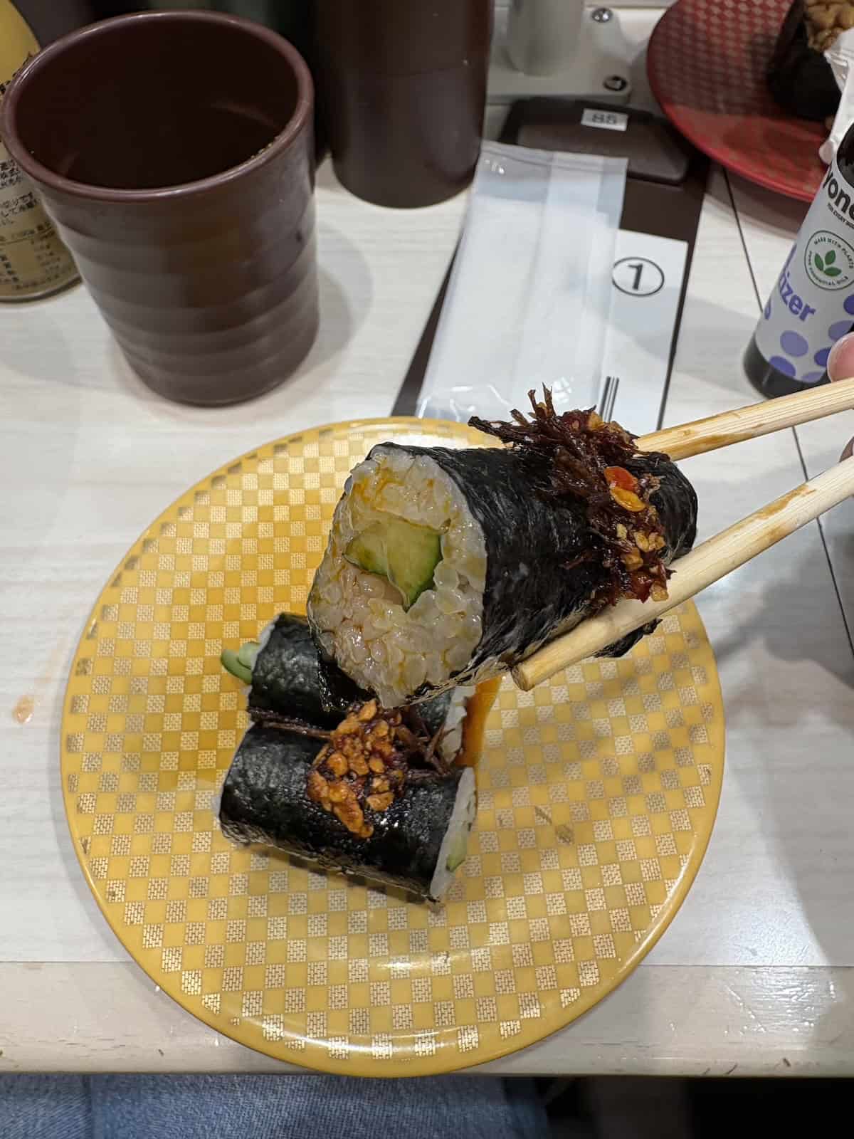The cucumber sushi roll on a yellow plate at Uobei Shibuya