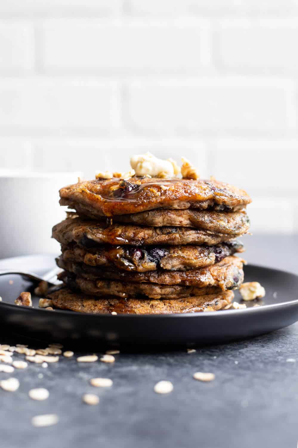 a stack of dark brown pancakes on a black plate
