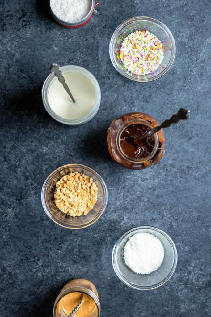 melted chocolate, coconut butter, peanut butter, and chocolate-covered pretzel toppings