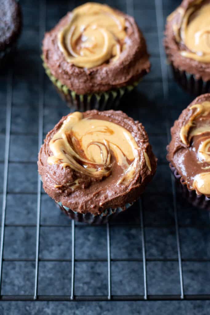 frosted vegan chocolate cupcakes on a cooling rack