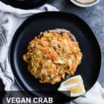 a vegan crab caked-stuffed portobello mushroom on a plate with a lemon slice