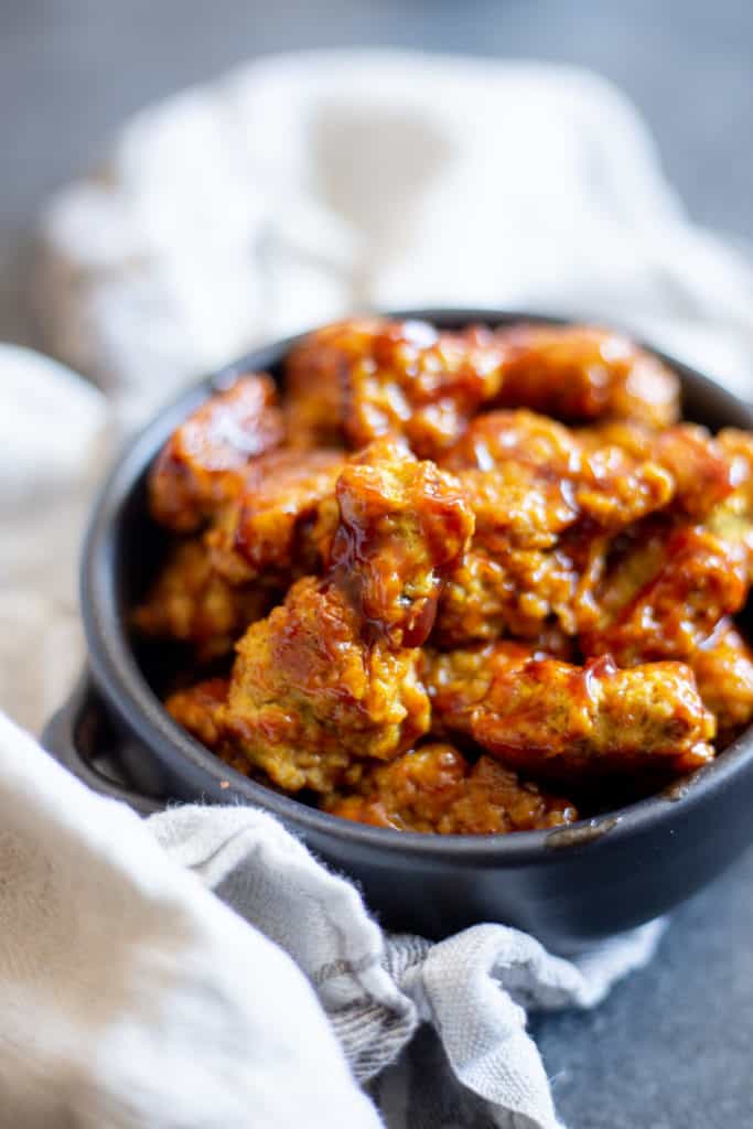 vegan bbq seitan nuggets in a black bowl on a dark background