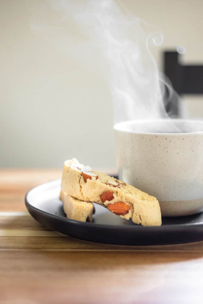 vegan lemon biscotti and a cup of tea on a black plate