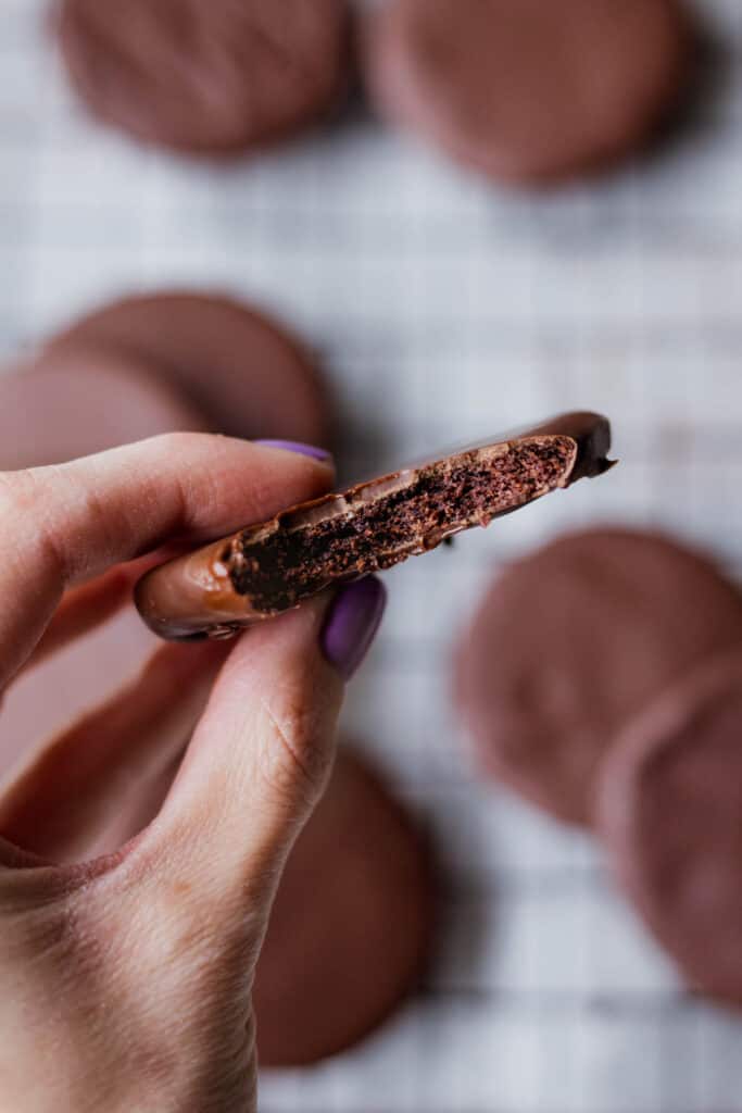 a hand holding a bitten vegan thin mint cookie