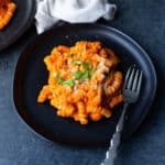 vegan vodka sauce pasta on a black plate with a fork