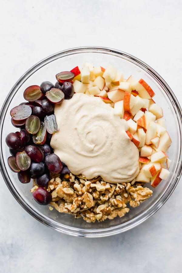 walnuts, hummus, apples, and grapes in a bowl